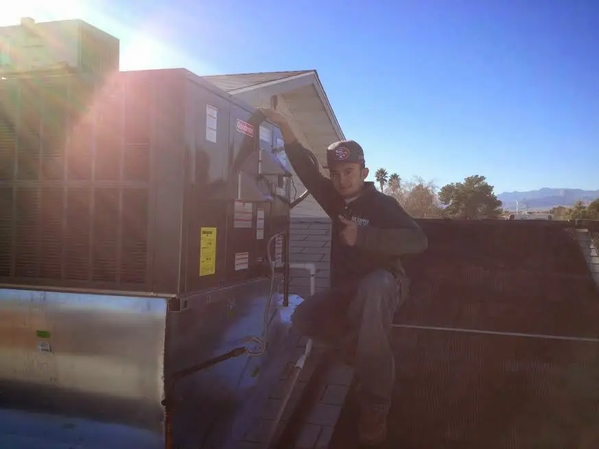 HVAC technician performing HVAC Inspection on a rooftop unit in Grosse Pointe Park
